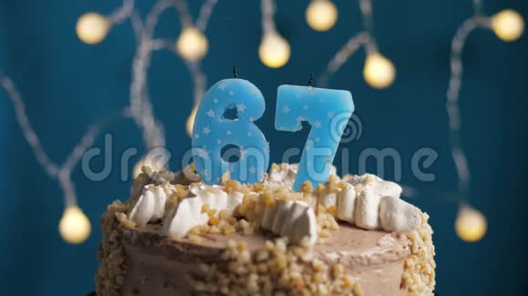 生日蛋糕蓝色背景上有67根蜡烛蜡烛吹灭了慢动作和特写视频的预览图