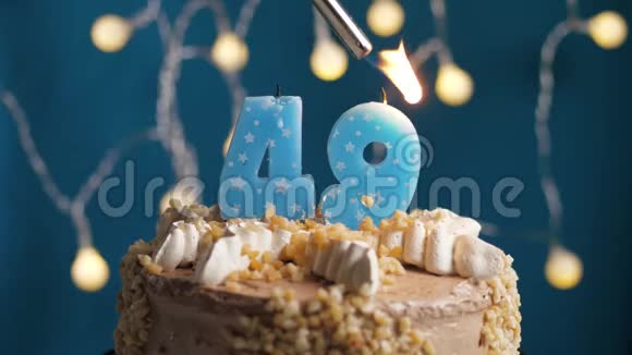 生日蛋糕蓝色背景上有49支蜡烛蜡烛吹灭了慢动作和特写视频的预览图
