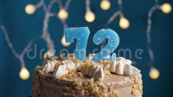 生日蛋糕72号蜡烛在蓝色的背景上蜡烛吹灭了慢动作和特写视频的预览图