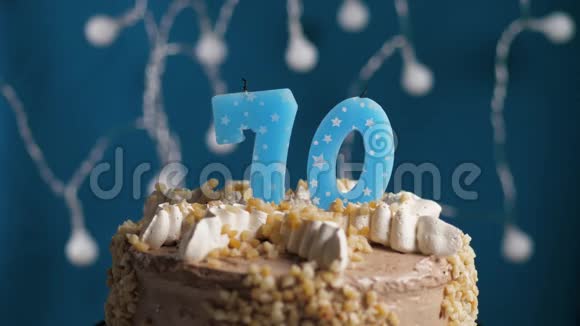 生日蛋糕70号蜡烛在蓝色的背景上蜡烛吹灭了慢动作和特写视频的预览图