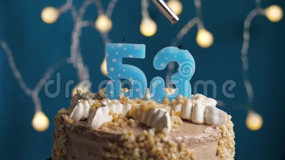 生日蛋糕蓝色背景上有53支蜡烛蜡烛吹灭了慢动作和特写视频的预览图
