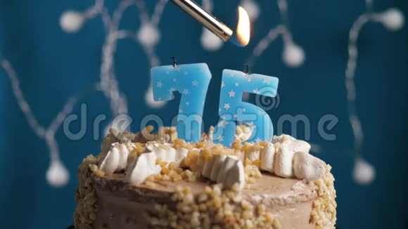 生日蛋糕75号蜡烛在蓝色的背景上蜡烛吹灭了慢动作和特写视频的预览图