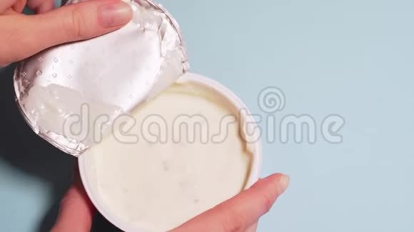 椰奶中的环保腐乳女性的手从一罐凝乳膏中撕下盖子你的复制空间视频的预览图