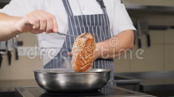 不可辨认的男厨师用橄榄油在热锅里炸一块鸭肉慢镜头烹饪视频的预览图