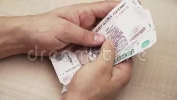 特写镜头那家伙把钱数在手里钞票上景俄罗斯货币红宝石视频的预览图