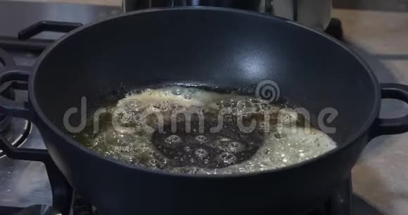 一个女人在热锅里用融化的黄油放入切碎的大蒜视频的预览图