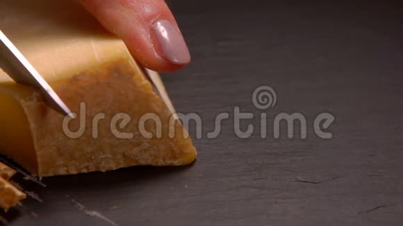 刀把硬干酪切成黑色表面的薄片视频的预览图