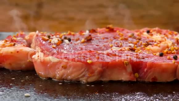 撒上胡椒和香料的肉在石烤架上煎炸视频的预览图