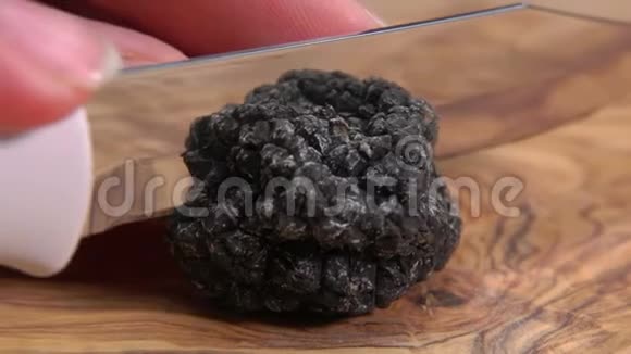 刀在木板上剪下一个罕见的黑松露蘑菇视频的预览图