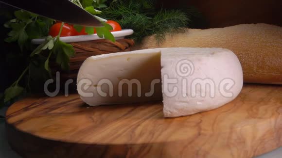 刀把美味的法国奶酪切成三角形视频的预览图