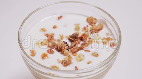 人把蜂蜜倒入酸奶与麦片接近美味健康早餐的主要组成部分清洁食品视频的预览图