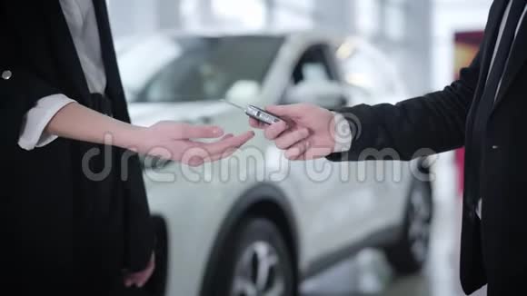 为一位身穿西装面目全非的年轻女子送车钥匙的白人男性经销商的特写女顾客拿钥匙视频的预览图
