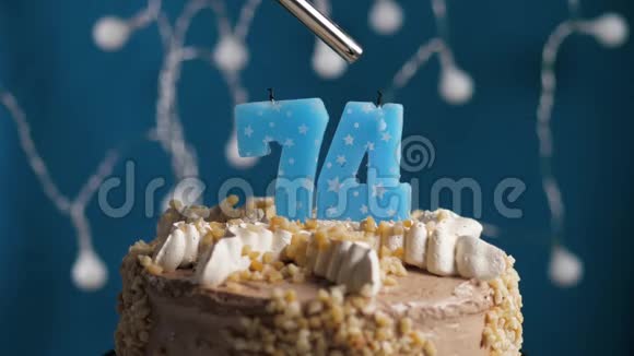 生日蛋糕蓝色背景上有74根蜡烛蜡烛吹灭了慢动作和特写视频的预览图