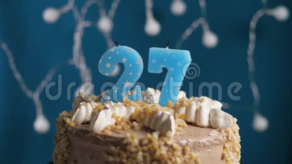 生日蛋糕蓝色背景上有27支蜡烛蜡烛吹灭了慢动作和特写视频的预览图
