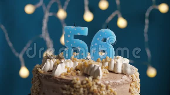生日蛋糕蓝色背景上有56支蜡烛蜡烛吹灭了慢动作和特写视频的预览图
