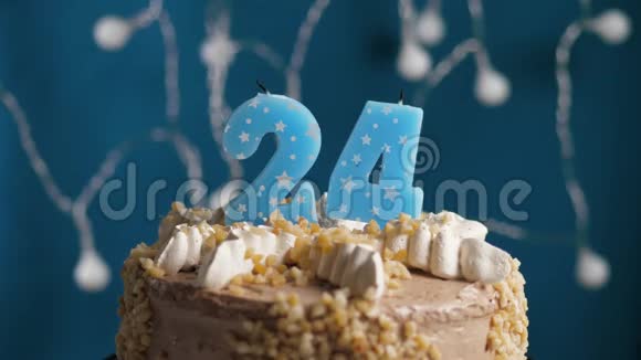生日蛋糕蓝色背景上有24支蜡烛蜡烛吹灭了慢动作和特写视频的预览图