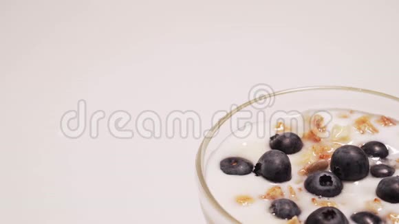 健康麦片加无麸质酸奶女孩吃了一勺酸奶和一些蓝莓视频的预览图