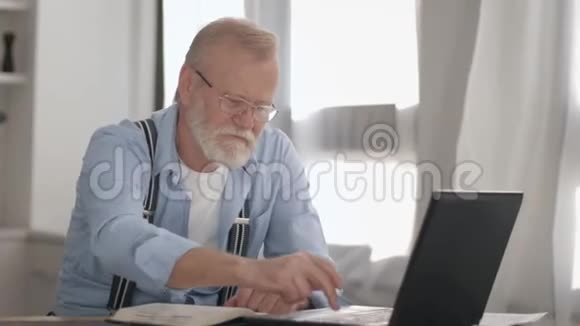 现代有魅力的戴着眼镜的灰色胡子的养老金领取者在网上支付公用事业费视频的预览图