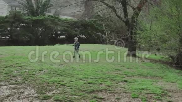可爱的男孩在公园的草地上奔跑视频的预览图