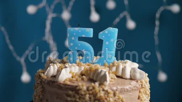 生日蛋糕蓝色背景上有51支蜡烛蜡烛吹灭了慢动作和特写视频的预览图