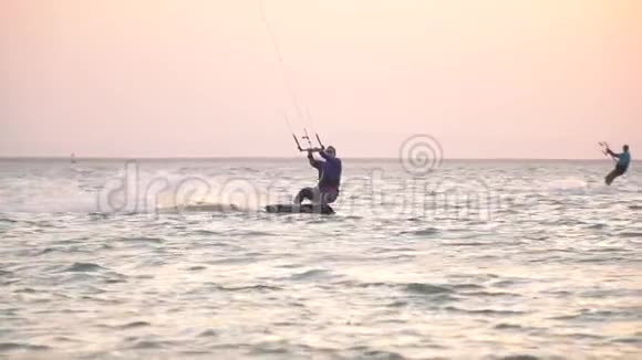 一个冲浪风筝的人在海中表演空中特技的大跳跃视频的预览图