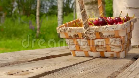 把装满成熟樱桃的篮子放在木桌上视频的预览图