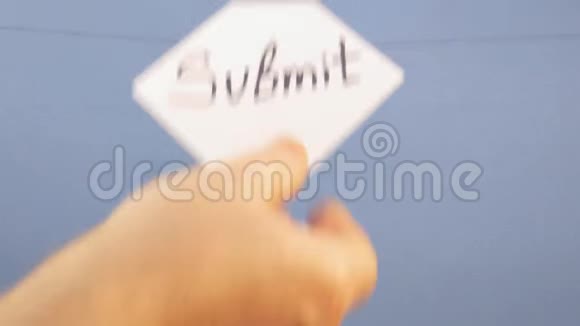 一个男人挂着一张白纸上面写着黑色的铭文在蓝色的背景上提交视频的预览图