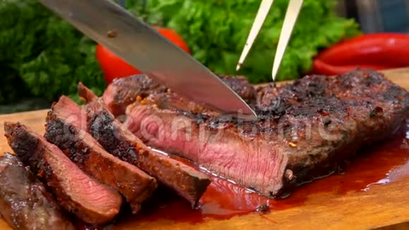 准备好的肉排用刀切在木板上视频的预览图