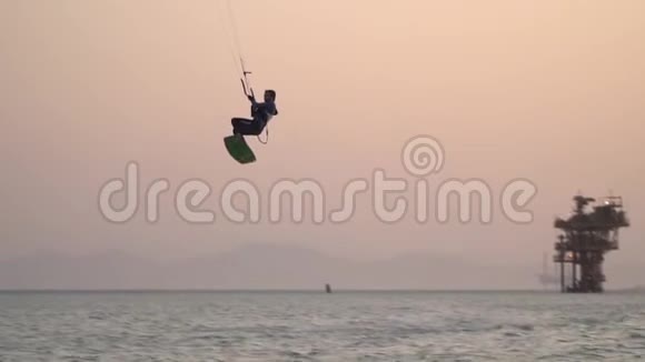 风筝冲浪者在海面上空高空飞行降落在水面上滑行视频的预览图