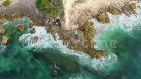 透明的绿松石海浪在棕色岩石海岸翻滚视频的预览图