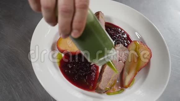 厨师烹饪和上菜不错的晚餐特写镜头美味的一块肉和甜红梨一起供应视频的预览图