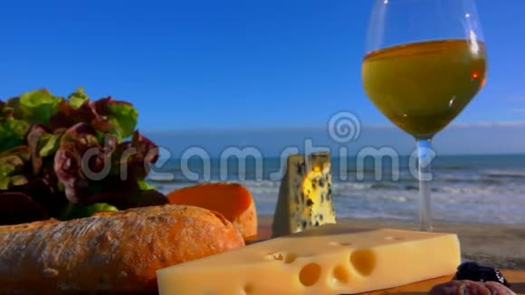 带着葡萄酒各种奶酪和橄榄在海边的浪漫野餐视频的预览图