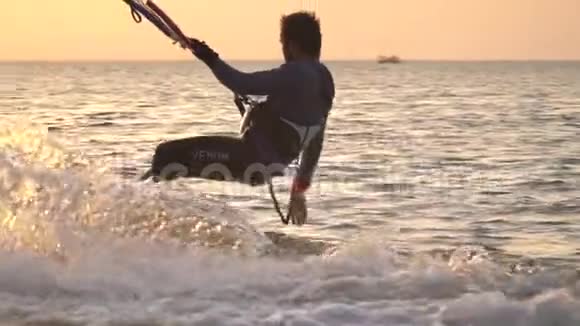 风筝冲浪者在滑翔做后滚日落时接触水视频的预览图