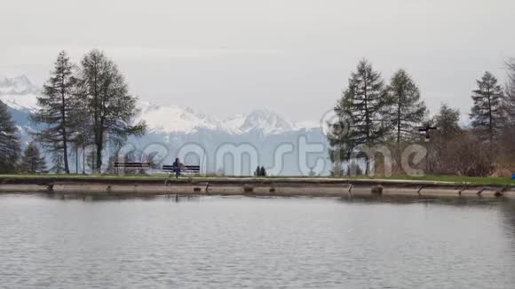 旅游女孩坐在湖边的长凳上从背包里拿出智能手机总计划视频的预览图