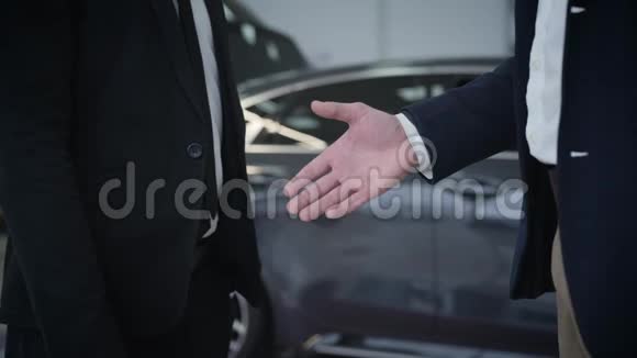 两个面目全非的高加索男人在汽车经销商面前握手握手视频的预览图