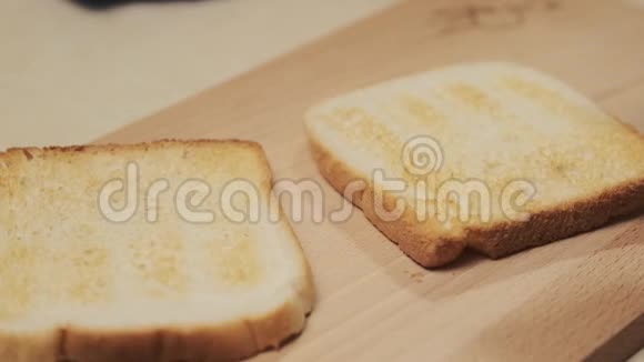 用一把刀在烤面包上用手抹黄油抹上黄油视频的预览图