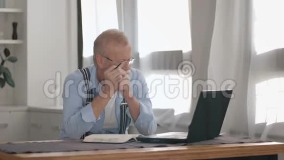 现代老年男性头发灰白戴着视力眼镜因为银行养老金账户的问题而感到紧张视频的预览图