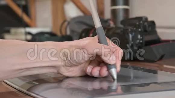 一位男性设计师的特写镜头借助他的笔记本电脑平板电脑和笔笔在他的背景下视频的预览图