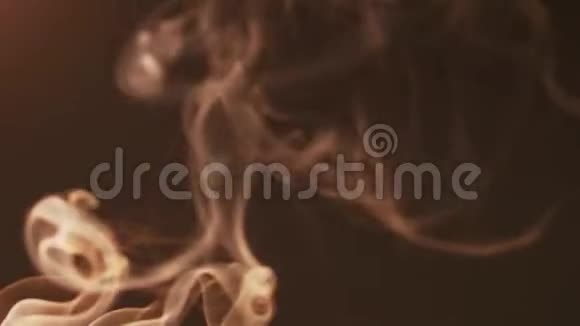 黑暗背景上的电影轻烟向不同方向移动形成美丽的人物的概念视频的预览图