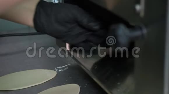 用擀面机将厨师的双手擀出面团厨房制作Khinkali的过程视频的预览图