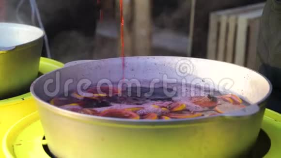 在圣诞节市场上用瓢舀的蒸热覆盖葡萄酒视频的预览图