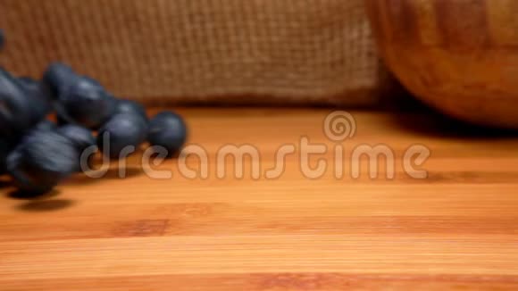 成熟的蓝莓在桌子的木制表面上滚动视频的预览图