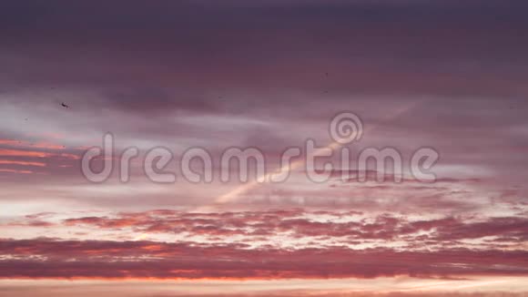 飞机正在转弯日落时飞行橙色粉红色和紫色的云视频的预览图