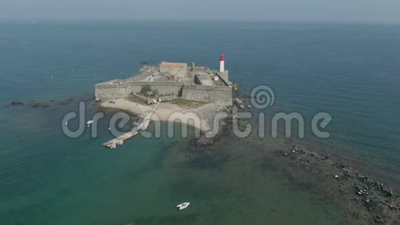小岛上有灯塔的老海堡的空中全景视频的预览图