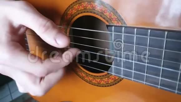 浅棕色吉他上的琴弦的枚举在演奏乐器视频的预览图