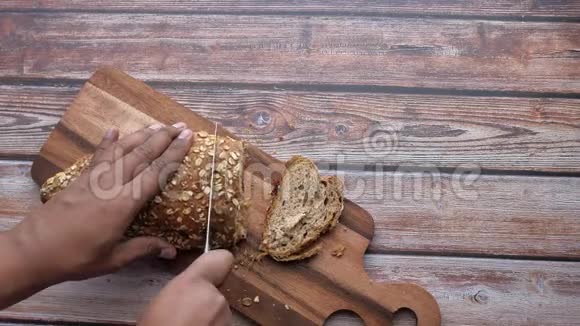 男子手在砧板上切面包的俯视图视频的预览图