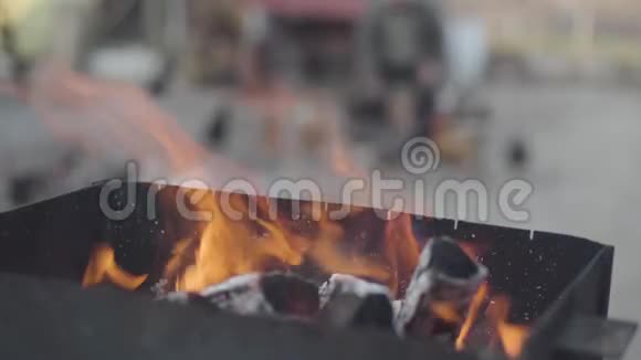烧烤架上红色火焰燃烧的特写镜头就像老白种人女人在后台喂鸡一样视频的预览图