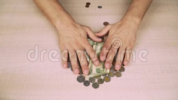 美元钞票和硬币那家伙把剩下的钱放在桌子上贫穷和债务经济危机特写视频的预览图