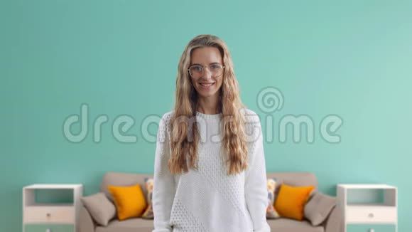 微笑的女人在蓝色的房间背景上出现了大拇指视频的预览图