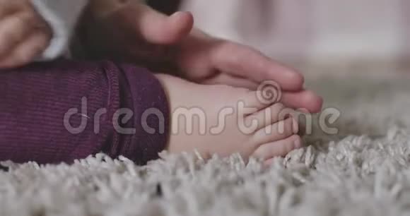 女性高加索手的特写抚摸小宝宝脚温柔母亲的快乐幸福生活方式视频的预览图